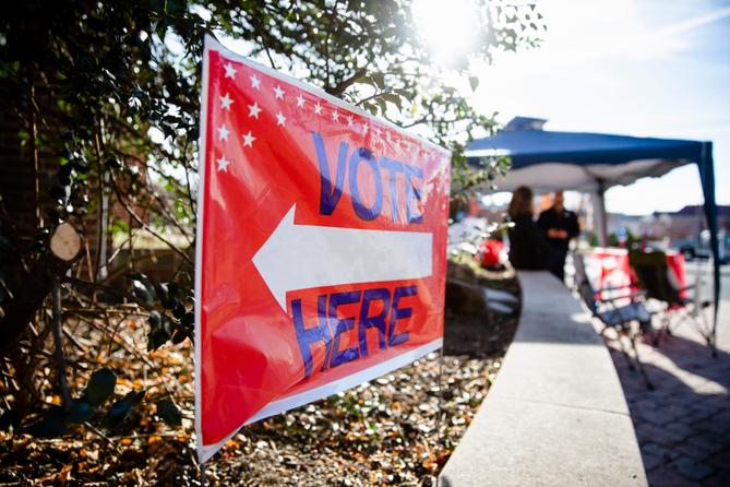 A sign directing people to "vote here" is seen in Camp Hill, Pennsylvania on midterm Election Day 2022.