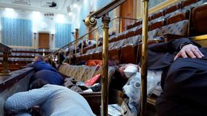 People shelter in the House gallery as protesters try to break into the House Chamber at the U.S. Capitol on Wednesday, Jan. 6, 2021, in Washington. (AP Photo/Andrew Harnik)