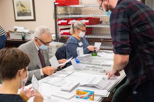 Volunteers open and sort mail-in ballots in Erie while poll watchers observe. Volunteers open and sort mail-in ballots in Erie while poll watchers observe.