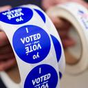 A poll worker holds voting stickers for community members Nov. 7, 2023, at Central Elementary School in Allentown, Lehigh County, Pennsylvania.