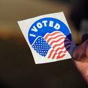 A voter holds an “I Voted” sticker at Memorial Hall in Jim Thorpe, Pennsylvania in 2022.