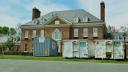 Large waste disposal bins sit out front of the Pennsylvania governor’s residence as crews work nine days after an alleged arson.