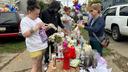 People gather at a memorial in Erie, Pa., Sunday, Oct. 11, 2026, outside the home where authorities say a gunman killed several people before killing himself on Oct. 9.