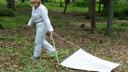 Dr. Danielle Tufts collects ticks for research by dragging a cloth along the ground.
