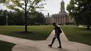A person walks on the campus of Penn State Main in State College, Pa.