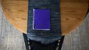 A purple notebook on a dining room table.