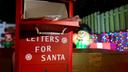 A red and white mailbox reading "Letters for Santa" surrounded by holiday decor.