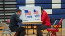 Two voters fill out ballots at Central Bucks East High School in Buckingham, Pa.