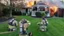 Firewomen of Alpha Fire Company are seen gearing up outside a burning building.