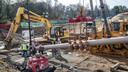 Pipefitters work to connect a long segment of pipe that is being suspended in air to make it ready to be pulled underground in a residential area of West Chester, Pennsylvania, in November 2019.