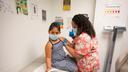 A child receives a vaccine from a nurse.