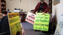 Sister Anne McCarthy with the Benedictine Sisters of Erie looks through her signs protesting President Trump’s nationwide immigration crackdown.