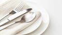 A stock image of a plate, silverware, and napkin.
