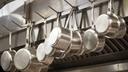 A stock image of pans hanging in a restaurant.