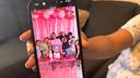 Wendys Martinez holds up her cell phone showing a photo of her husband, Carlos Moreno, and their children.
