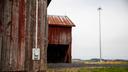 A rural building with a cell tower in the background.