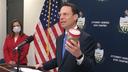 Pennsylvania Attorney General Josh Shapiro, right, holds a jar of discolored tap water during a news conference. He said the sample was from the home of a state resident whose well had been tainted by nearby natural gas drilling.