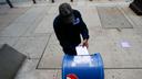A person drops an absentee ballot into a mailbox.