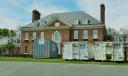 Large waste disposal bins sit out front of the Pennsylvania governor’s residence as crews work nine days after an alleged arson.
