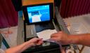 A polling judge helps guide a voter's ballot into a voting machine during the May 2022 Pennsylvania primary election.