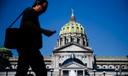 Man walks in front of Pennsylvania state capitol