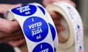 A poll worker holds voting stickers for community members Nov. 7, 2023, in Allentown, Pennsylvania.