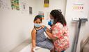 A child receives a vaccine from a nurse.