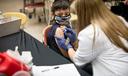 A child receives a vaccine from a nurse