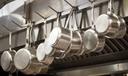 A stock image of pans hanging in a restaurant.