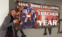 Madeline Loring poses with a sign celebrating her Teacher of The Year Award.
