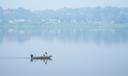 People fish on the Susquehanna River amidst haze from Canadian wildfires, June 29, 2023, in Harrisburg, Pa.