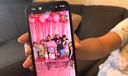 Wendys Martinez holds up her cell phone showing a photo of her husband, Carlos Moreno, and their children.