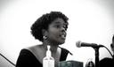 Jazmin Evans, a Philadelphia-based health advocate, speaks into a microphone.