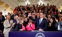 Pa. Gov. Josh Shapiro holds up Senate President Pro Tempore Kim Ward's hand as he signs the first bill of his tenure.