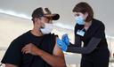 Giorgi Mushroom Company worker Juan Frutos gets a vaccine shot from Penn State Health nurse Christy Daniels during a clinic facilitated by Latino Connection's mobile unit. The Wolf administration hired the group this spring to address persistent disparities.