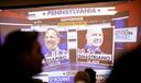 Early results for the governor’s race appear on screen at Doug Mastriano’s election night watch party in Camp Hill, PA.
