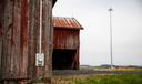 A rural building with a cell tower in the background.