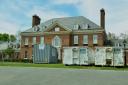 Large waste disposal bins sit out front of the Pennsylvania governor’s residence as crews work nine days after an alleged arson.
