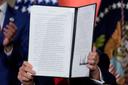 President Donald Trump holds a signed executive order on permitting for data center infrastructure.