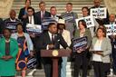 Rep. Jason Dawkins (center) speaks at a new conference urging the PA Senate to raise the minimum wage.