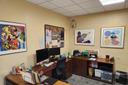 An office with four pieces of art on the walls