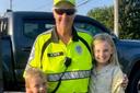 Crossing guard Jan Weaver hugs two children