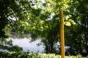 A pipeline marker along a riverbank.