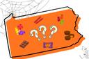 A Halloween-themed illustration of Pennsylvania featuring candies, cobwebs, skeletons, and a black cat.