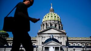 Man walks in front of Pennsylvania state capitol