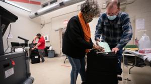 Three election workers put provisional ballots in the hopper at the 5th and 9th division of the 26th Ward after the polls closed at the polling place at Barry Recreation Center, in South Philadelphia, on Election Day.