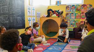 Tanisha Baylor (right) during “circle time” with the 4-year-old students under her care at The Willow School. The Montgomery County center for children has been significantly impacted by staffing shortages.
