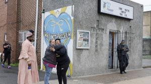 Penny Martin (left) and the Rev. Michelle Simmons, founder and executive director of Why Not Prosper, hug outside of a recovery home in Philadelphia. Simmons said the new licensing system will "make owners … step up their game."