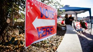 A sign directing people to "vote here" is seen in Camp Hill, Pennsylvania on midterm Election Day 2022.