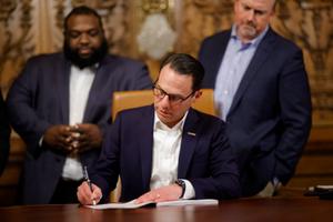 Gov. Josh Shapiro signs the final pieces of the 2023 Pennsylvania budget in the Capitol.